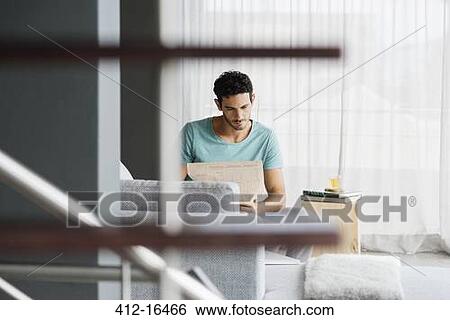 Man reading newspaper in livingroom View Large Photo Image Stock Photograph - Man reading newspaper in livingroom. Fotosearch
