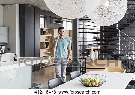Man talking on cell phone at home View Large Photo Image Stock Photo - Man talking on cell phone at home. Fotosearch