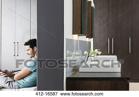 Man texting with cell phone in bedroom View Large Photo Image Stock Photo - Man texting with cell phone in bedroom. Fotosearch