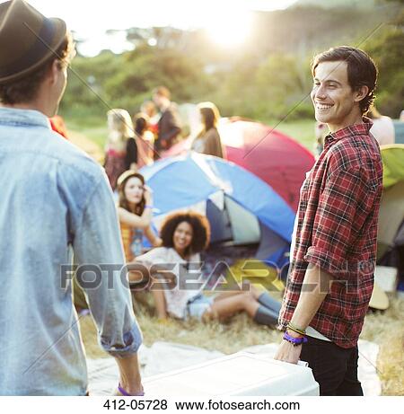 Men carrying cooler outside tents at music festival View Large Photo Image Stock Photo - Men carrying cooler outside tents at music festival. Fotosearch