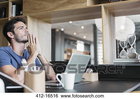 Pensive man at laptop in home office View Large Photo Image Stock Photograph - Pensive man at laptop in home office. Fotosearch