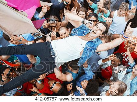 Performer singing and crowd surfing at music festival View Large Photo Image Stock Photo - Performer singing and crowd surfing at music festival. Fotosearch