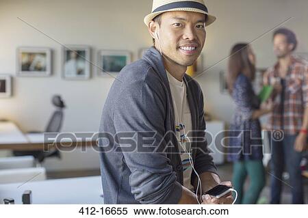 Portrait of casual businessman listening to music with mp3 player and headphones View Large Photo Image Stock Photography - Portrait of casual businessman listening to music with mp3 player and headphones. Fotosearch
