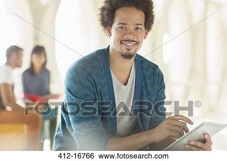 Stock Photograph - Portrait of casual businessman using digital tablet. Fotosearch