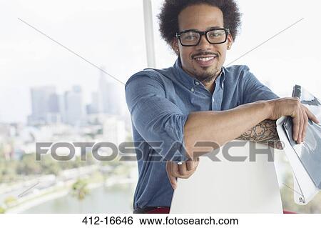 Portrait of confident businessman holding folder View Large Photo Image Stock Photograph - Portrait of confident businessman holding folder. Fotosearch