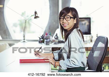 Portrait of confident businesswoman working at desk View Large Photo Image Stock Image - Portrait of confident businesswoman working at desk. Fotosearch