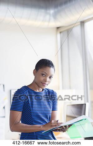 Portrait of confident businesswoman with paperwork View Large Photo Image Stock Photo - Portrait of confident businesswoman with paperwork. Fotosearch