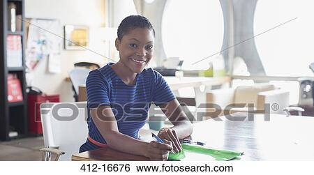 Portrait of confident businesswoman working at desk in sunny office View Large Photo Image Stock Photograph - Portrait of confident businesswoman working at desk in sunny office. Fotosearch