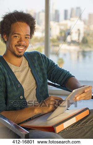 Stock Image - Portrait of confident casual businessman using digital tablet. Fotosearch