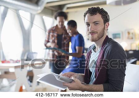 Portrait of confident casual businessman with paperwork in office View Large Photo Image Stock Photo - Portrait of confident casual businessman with paperwork in office. Fotosearch