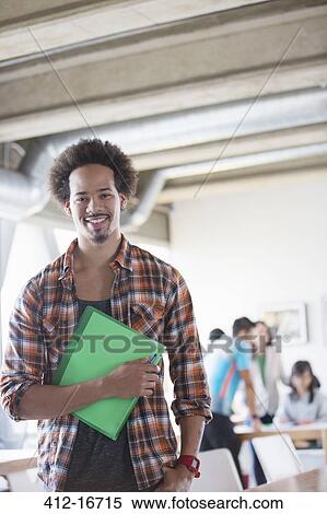 Portrait of confident casual businessman holding folder in office View Large Photo Image Stock Photography - Portrait of confident casual businessman holding folder in office. Fotosearch