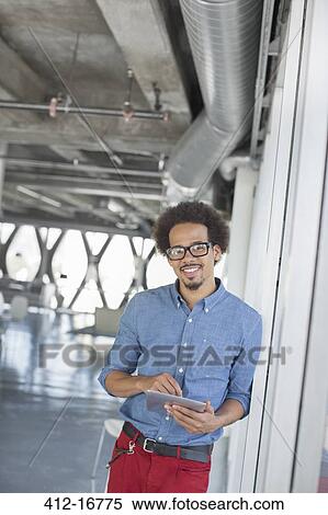 Portrait of confident casual businessman using digital tablet in office View Large Photo Image Stock Photography - Portrait of confident casual businessman using digital tablet in office. Fotosearch