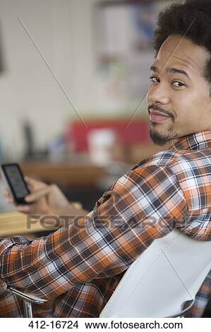 Portrait of confident man text messaging with cell phone View Large Photo Image Picture - Portrait of confident man text messaging with cell phone. Fotosearch