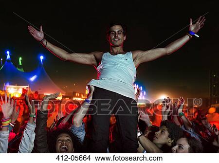 Picture - Portrait of confident performer with fans cheering in background. Fotosearch