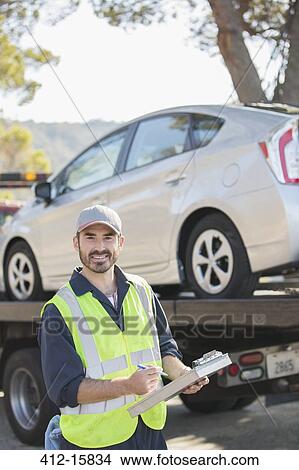 Picture - Portrait of confident roadside mechanic with paperwork. Fotosearch