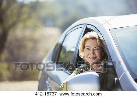 Portrait of confident senior woman leaning out car window View Large Photo Image Stock Photo - Portrait of confident senior woman leaning out car window. Fotosearch