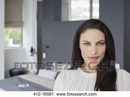 Stock Image - Portrait of confident woman in bedroom. Fotosearch