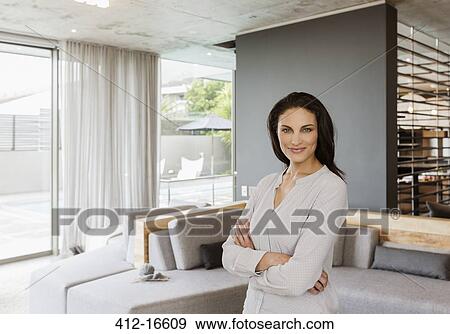 Portrait of confident woman in living room View Large Photo Image Stock Photo - Portrait of confident woman in living room. Fotosearch