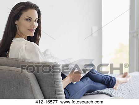 Portrait of confident woman reading magazine on chaise lounge View Large Photo Image Stock Photo - Portrait of confident woman reading magazine on chaise lounge. Fotosearch