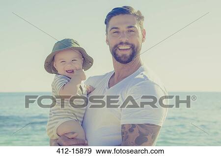 Portrait of father and baby son smiling on sunny beach View Large Photo Image Stock Photo - Portrait of father and baby son smiling on sunny beach. Fotosearch