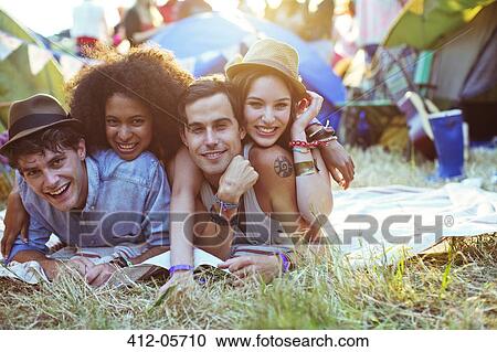 Portrait of friends laying on blanket outside tents at music festival View Large Photo Image Stock Image - Portrait of friends laying on blanket outside tents at music festival. Fotosearch