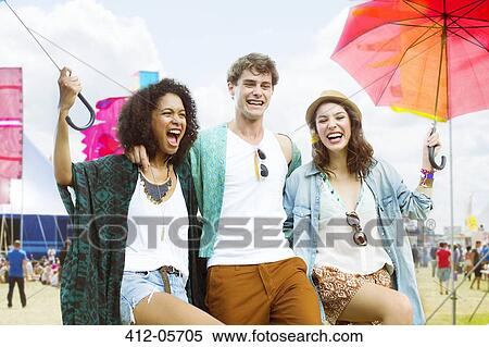 Portrait of friends with umbrellas at music festival View Large Photo Image Stock Photography - Portrait of friends with umbrellas at music festival. Fotosearch