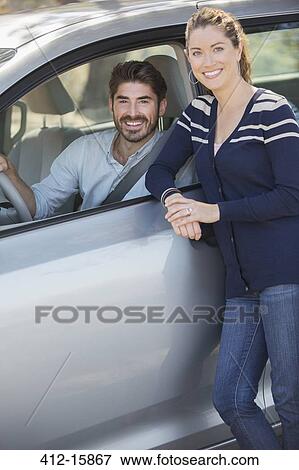 Portrait of happy couple inside and outside car View Large Photo Image Stock Photo - Portrait of happy couple inside and outside car. Fotosearch