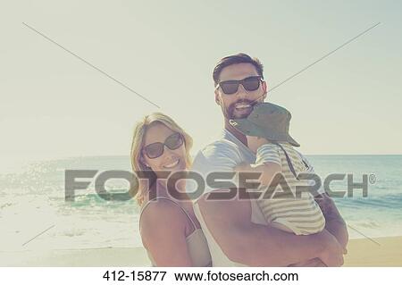 Stock Photo - Portrait of happy family on sunny beach. Fotosearch
