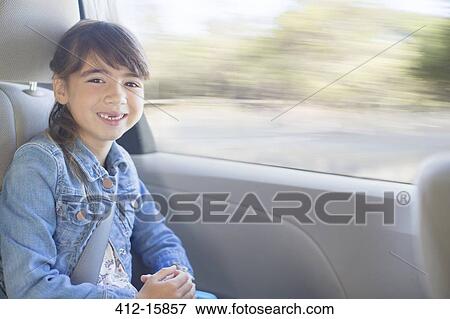 Stock Photo - Portrait of happy girl in back seat of car. Fotosearch