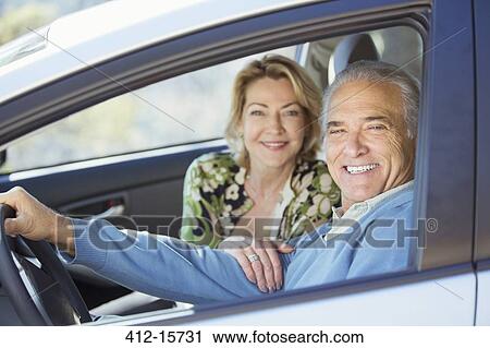 Stock Image - Portrait of happy senior couple in car. Fotosearch