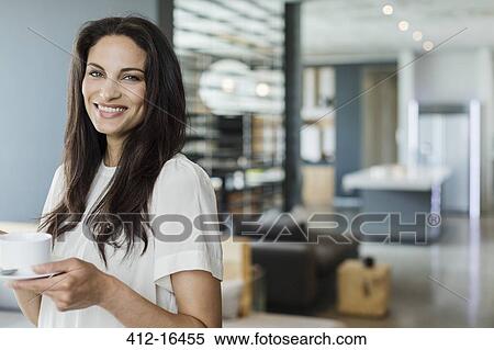 Stock Photography - Portrait of happy woman drinking coffee at home. Fotosearch