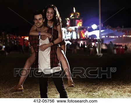 Portrait of man piggybacking woman at music festival View Large Photo Image Stock Photograph - Portrait of man piggybacking woman at music festival. Fotosearch
