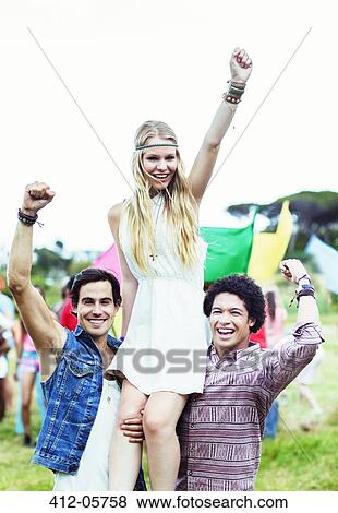 Portrait of men carrying woman at music festival View Large Photo Image Stock Photo - Portrait of men carrying woman at music festival. Fotosearch