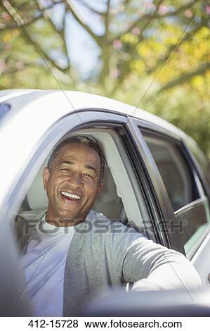 Stock Photo - Portrait of senior man laughing in car. Fotosearch