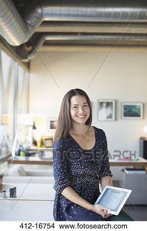 Picture - Portrait of smiling businesswoman with digital tablet in office. Fotosearch