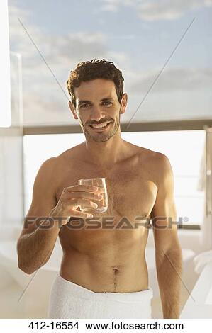 Portrait of smiling man drinking water in bathroom View Large Photo Image Picture - Portrait of smiling man drinking water in bathroom. Fotosearch