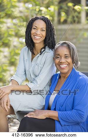 Portrait of smiling mother and daughter on patio View Large Photo Image Stock Photograph - Portrait of smiling mother and daughter on patio. Fotosearch