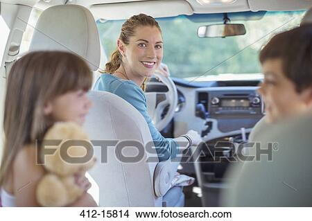 Picture - Portrait of smiling mother with family in car. Fotosearch