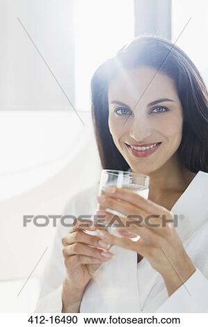 Portrait of smiling woman in bathrobe drinking water View Large Photo Image Stock Image - Portrait of smiling woman in bathrobe drinking water. Fotosearch