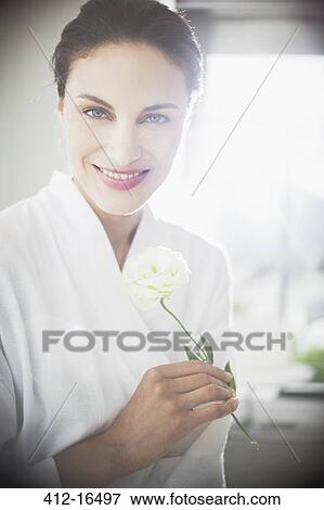 Portrait of smiling woman in bathrobe holding white rose View Large Photo Image Stock Photo - Portrait of smiling woman in bathrobe holding white rose. Fotosearch