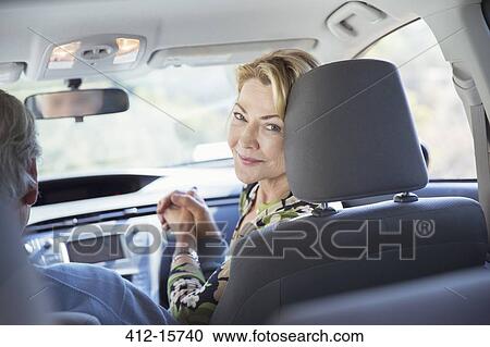 Stock Image - Portrait of smiling woman inside car. Fotosearch