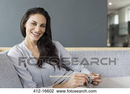 Portrait of smiling woman knitting on sofa View Large Photo Image Stock Image - Portrait of smiling woman knitting on sofa. Fotosearch