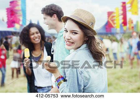Portrait of woman eating flavored ice with friends at music festival View Large Photo Image Stock Image - Portrait of woman eating flavored ice with friends at music festival. Fotosearch