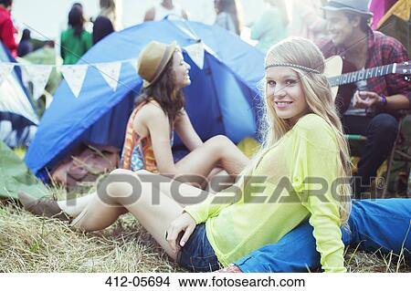 Portrait of woman hanging out with friends outside tent at music festival View Large Photo Image Picture - Portrait of woman hanging out with friends outside tent at music festival. Fotosearch