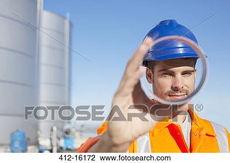 Portrait of worker looking through metal tube View Large Photo Image Stock Image - Portrait of worker looking through metal tube. Fotosearch