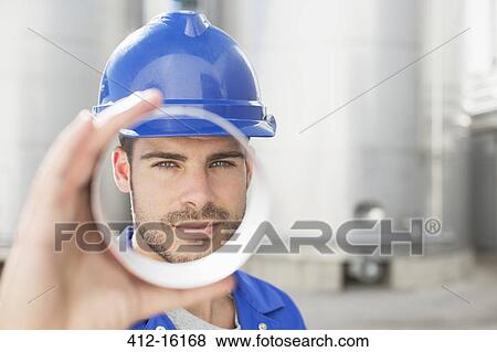 Portrait of worker looking through metal tube View Large Photo Image Stock Photo - Portrait of worker looking through metal tube. Fotosearch