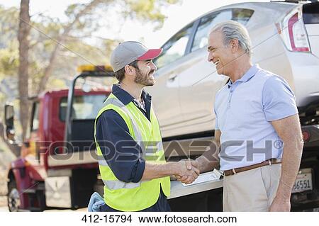 Picture - Roadside mechanic and man shaking hands. Fotosearch