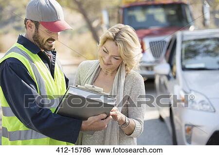 Roadside mechanic and woman reviewing paperwork View Large Photo Image Stock Photograph - Roadside mechanic and woman reviewing paperwork. Fotosearch