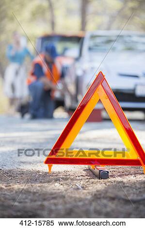 Roadside mechanic helping woman behind warning triangle View Large Photo Image Stock Photography - Roadside mechanic helping woman behind warning triangle. Fotosearch
