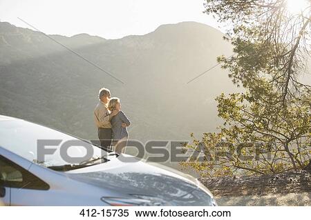Senior couple looking at mountain view outside car View Large Photo Image Stock Photography - Senior couple looking at mountain view outside car. Fotosearch